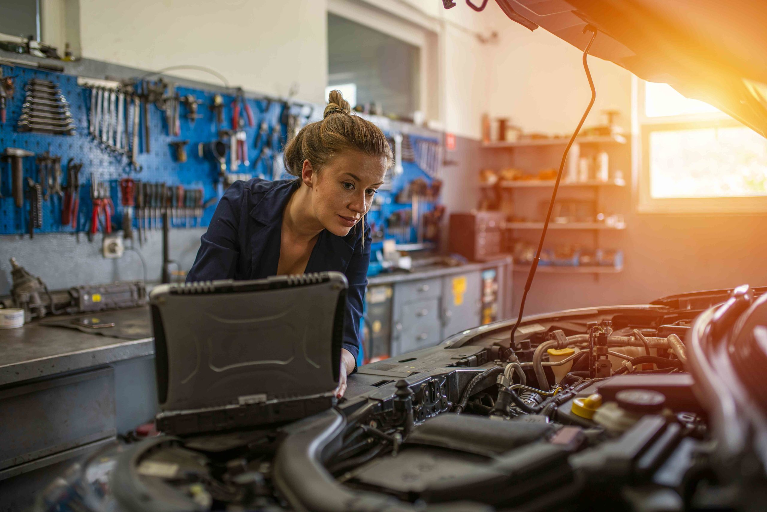 auto repair technician working on laptop in garahe